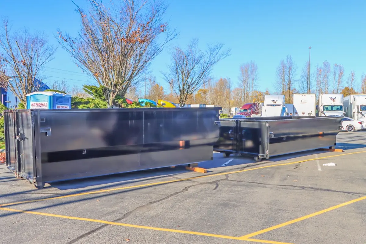 Professional dumpster rental service with roll-off container on residential driveway in Pimmit Hills